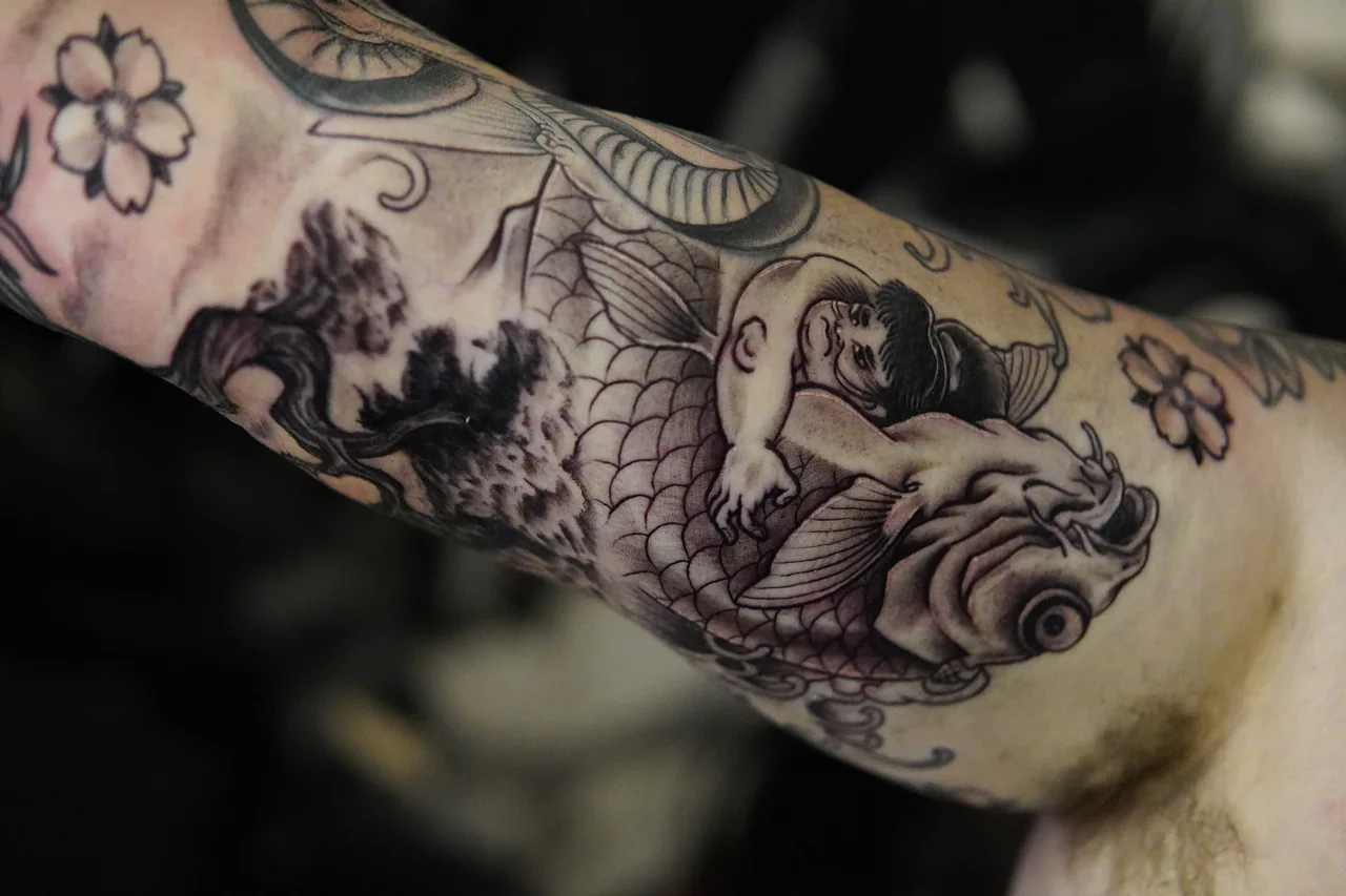 Black and grey koi and cherry blossom sleeve tattoo
